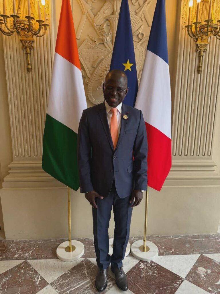 L'Honorable Penawelfa Karim Ouattara devant les drapeaux ivoirien et français